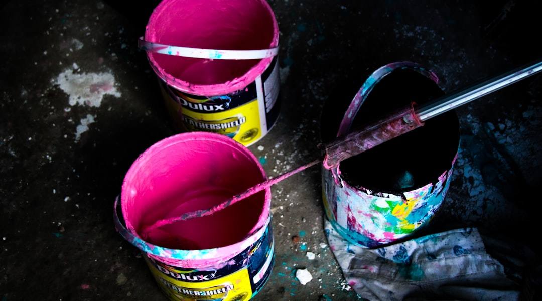 Cubos de pintura abiertos con brochas y rodillos